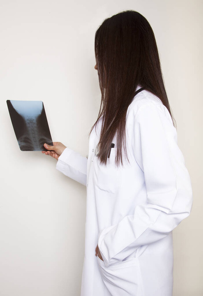 A női orvos megvizsgálja a röntgenfelvételt. Vizsgálószoba a kórházban. Orvosi és egészségügyi koncepció. - Fotó, kép