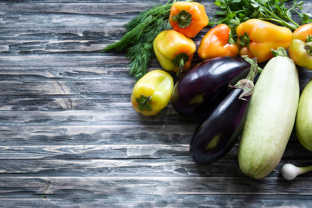Raw vegetables and herbs from garden. Organic harvest. Flat lay, copy space for text. Composition of eggplant, zucchini, carrots, peppers, parsley and dill. - Photo, Image
