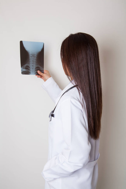 Ärztin untersucht den Röntgenfilm. Untersuchungsraum im Krankenhaus. Medizin und Gesundheitskonzept. - Foto, Bild