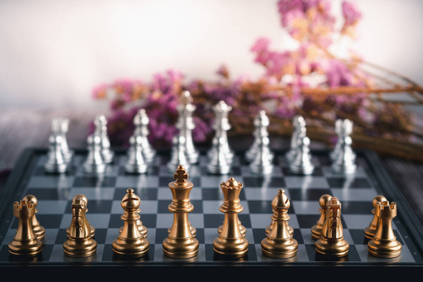 Vista frontale di una partita a scacchi su una scacchiera con fiori viola sfondo sfumato. Gioco d'affari strategia competitiva. Concetto di strategia per le imprese. - Foto, immagini