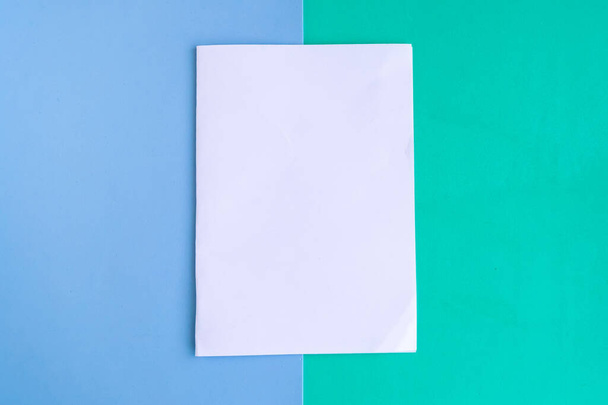 Blanco maqueta en blanco sobre fondo de color, espacio de copia para el texto - Foto, imagen