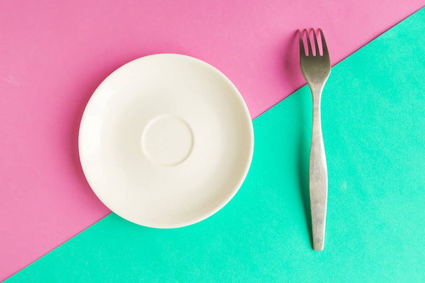 Empty plate and fork on color geometric background, minimal concept, copy space for the text - Фото, зображення