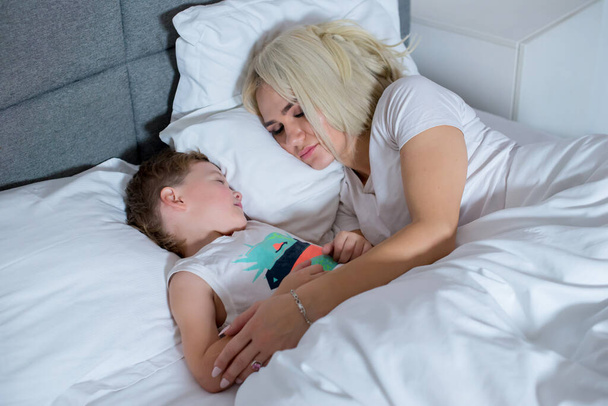 Mom sleeps with little son in bed at home. - Foto, immagini