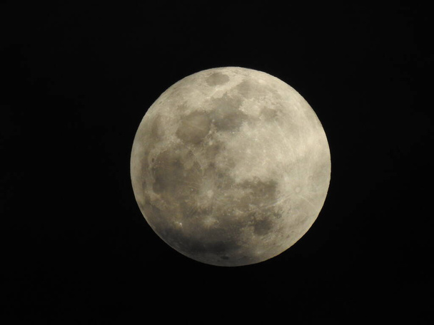Primer plano de Luna Llena Real y Natural en el Cielo por la noche en Bangalore, Karnataka, India en un fondo negro - Foto, imagen