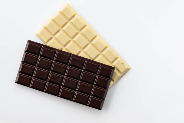 White and dark chocolate bars on a light background. - Foto, Imagen
