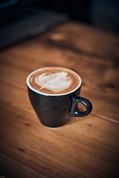 чашка гарячої латте художньої кави на дерев'яному столі, фокус на білому фої
 - Фото, зображення