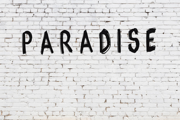 White brick wall with inscription paradise handwritten with black paint - Fotoğraf, Görsel