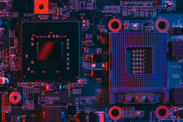 Concepto de tecnología de hardware en luz de neón. Placa base en luz azul-roja. Componente informático. Fotografía oscura.Neon Colors.Procesador de GPU. Zócalo CPU. - Foto, imagen