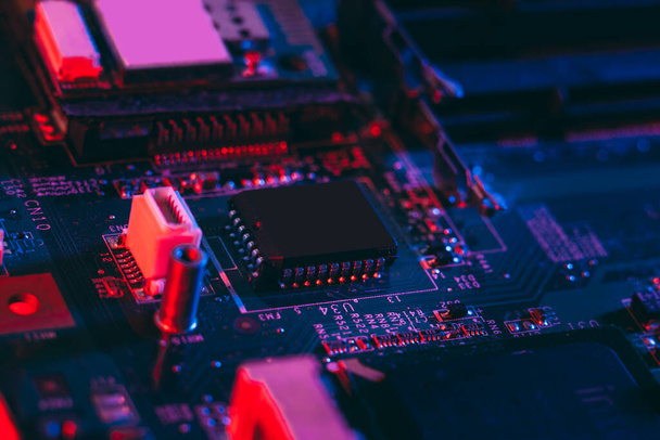 Hardware technology concept in neon light. Motherboard in blue-red light. Computer  component. Dark photo.Neon Colors.GPU processor. CPU - Φωτογραφία, εικόνα