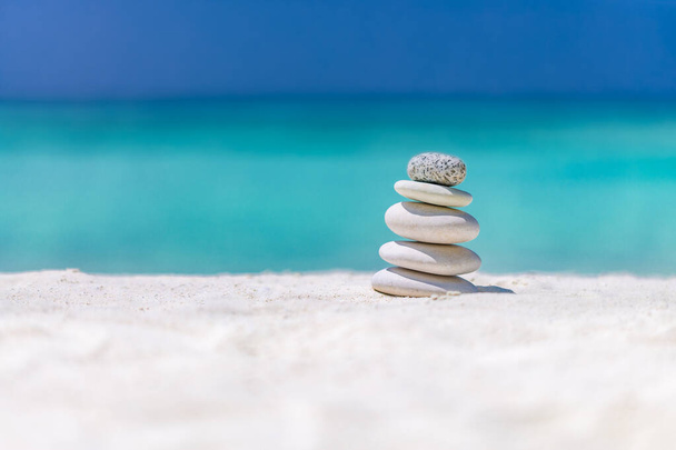 Kamienie zen do mediacji i relaksu, pozytywnej energii i wibracji. Kamienie Zen równowagi, kamyki stos nad błękitnym morzu. Kamienie piramidy balans na piasku plaży. Obiekt jest skupiony, tło jest zamazane.. - Zdjęcie, obraz