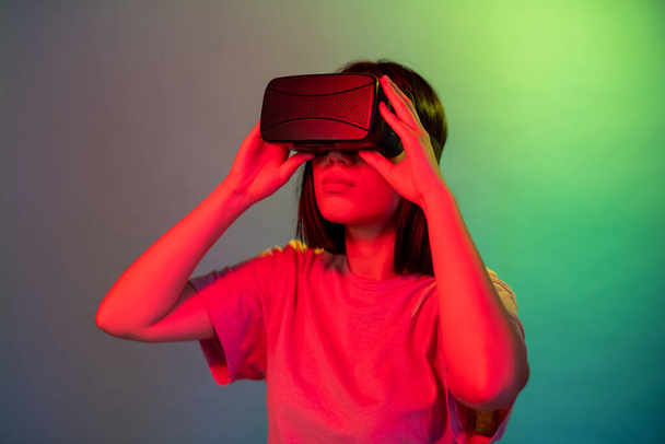 Asiatico donna isolato su sfondo verde utilizzando vr occhiali divertente fuga dalla realtà nel mondo virtuale - Foto, immagini