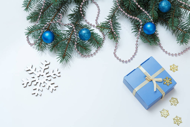 Χριστουγεννιάτικη διακόσμηση. Κουτί δώρου, κλαδιά ελάτης με μπάλες στο λευκό φόντο. Στο πάνω μέρος. Χριστούγεννα έννοια ευχετήρια κάρτα. - Φωτογραφία, εικόνα