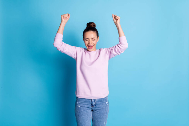 Photo of delighted positive cheerful girl raise fists scream yes celebrate lottery lucky win wear good look outfit isolated over blue color background - Foto, Imagen