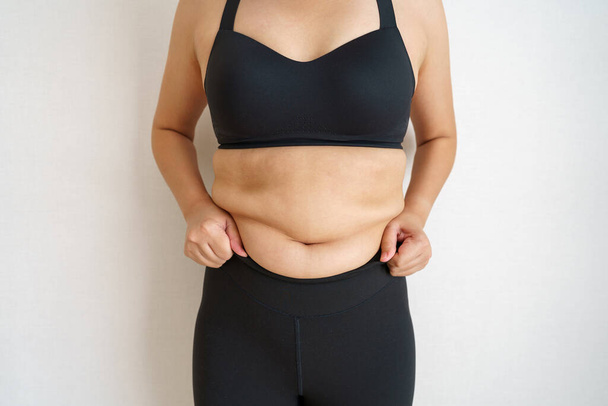 Naiset rasvaa vatsa. Lihava nainen käsi pitämällä liiallinen vatsa rasvaa. ruokavalion elämäntapa käsite vähentää vatsa ja muotoilla terve vatsa lihas. - Valokuva, kuva