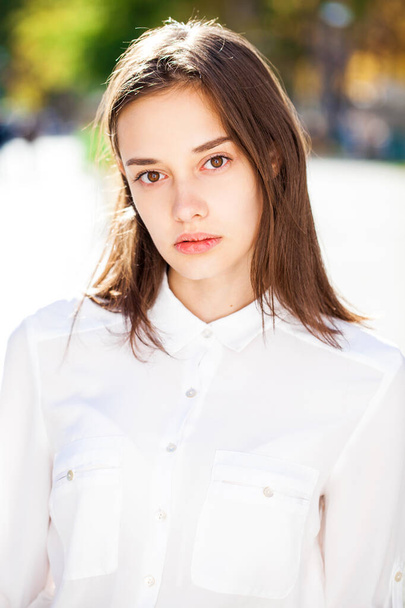 Close up portrait of a young beautiful girl in white shirt - 写真・画像
