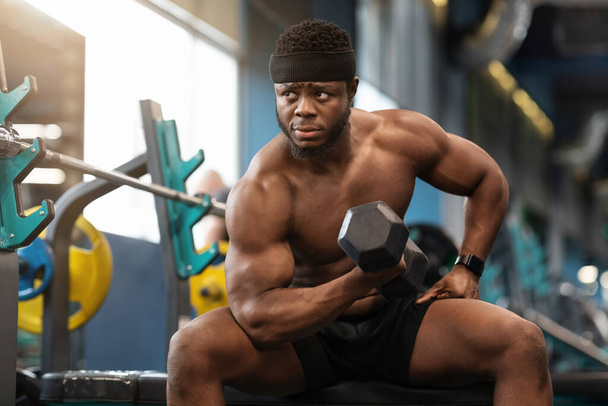 Концентрированный африканский мускулистый парень упражняется с штангой - Фото, изображение