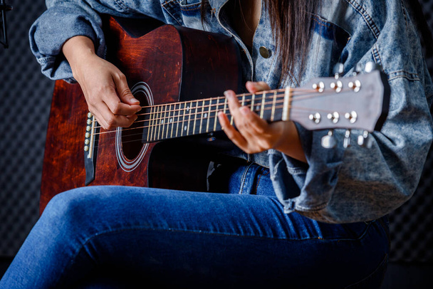 Close up woman fingers holding mediator with a Guitar recording a song in recording studio - Photo, Image