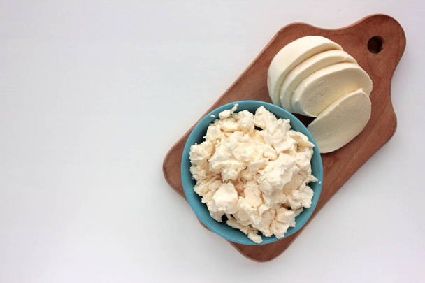 Diferentes tipos de queso en la mesa blanca. Vista aérea del queso cottage y la mozzarella. Copiar espacio. Enfoque selectivo - Foto, imagen