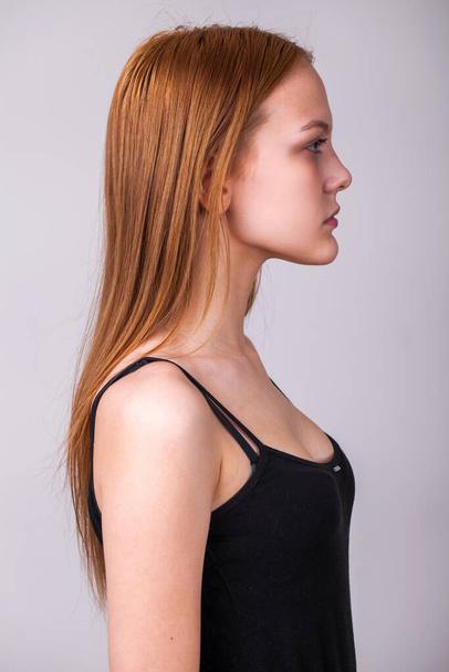 Portrait of young beautiful red hair woman in profile isolated on gray background - Foto, immagini