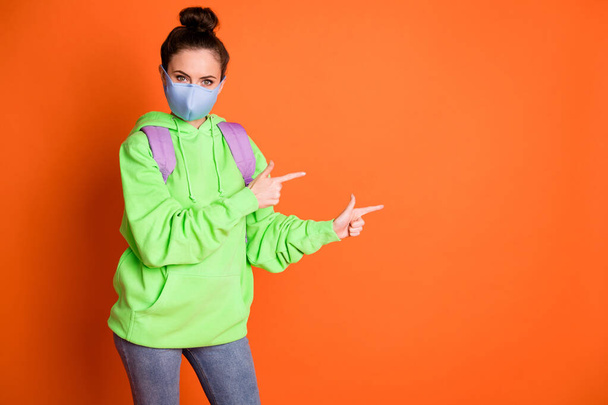 Full body portrait of young person direct fingers empty space wear pullover rucksack isolated on orange color background - Zdjęcie, obraz