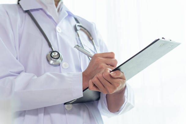 Close up of female doctor with a stethoscope on shoulder holding clipboard, Healthcare and Medical concept - Photo, Image