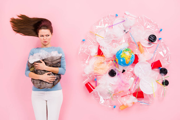 Top above high angle view upset eco activist girl hold rubbish bag look plastic cup glass plate disposal bottle surround globe dislike pollution flay lay isolated pastel color background - Photo, Image