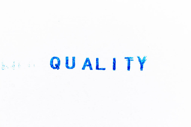 Μπλε χρώμα μελάνι από καουτσούκ σφραγίδα στην ποιότητα της λέξης σε λευκό φόντο χαρτί - Φωτογραφία, εικόνα