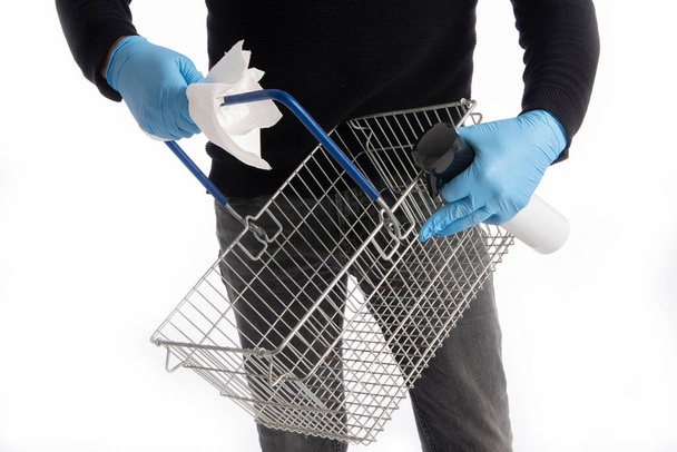 Cesta de la compra siendo limpiado por las manos con guantes, aislado sobre fondo blanco - Foto, Imagen