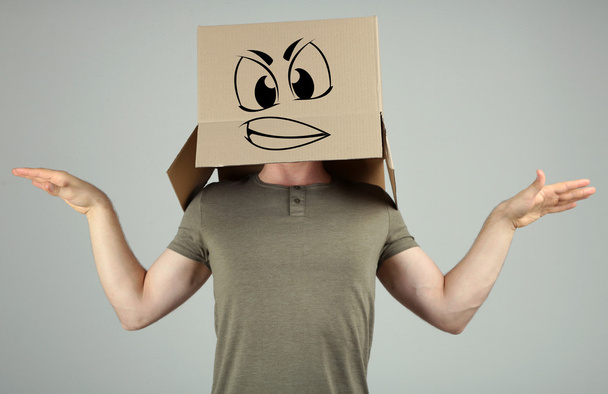 Man with cardboard box on his head on grey background - Foto, imagen