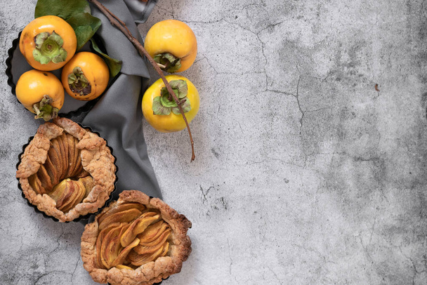 Připraven k jídlu sladký koláč s persimmony na šedém cementovém pozadí - Fotografie, Obrázek