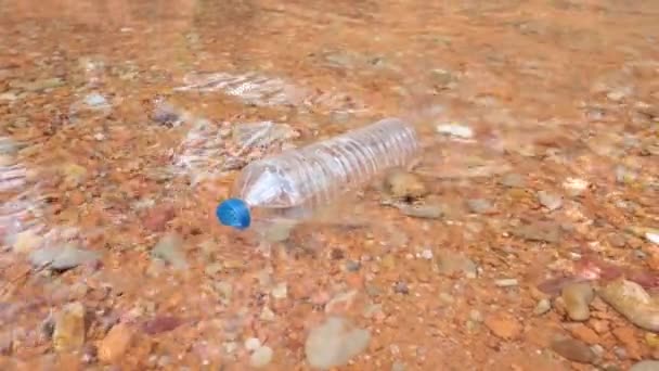 El deterioro ambiental, una botella de plástico en el curso de un río - Metraje, vídeo