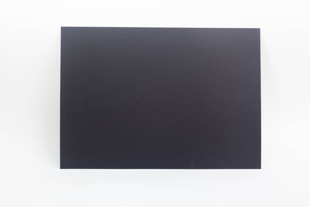 Black paper sheet against white background - Foto, imagen