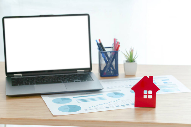 Concept d'investissement immobilier, ordinateur portable et papiers sur le bureau devant la fenêtre. concept d'entreprise - Photo, image