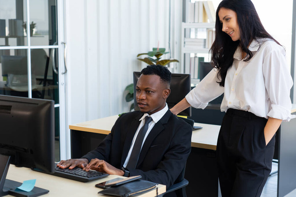 caucasian manager training young black new employee to work with computer in office. diversity and business concept - Photo, Image