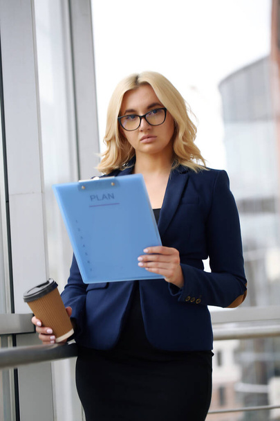 Business woman holding a writing tablet in the office. - Foto, imagen