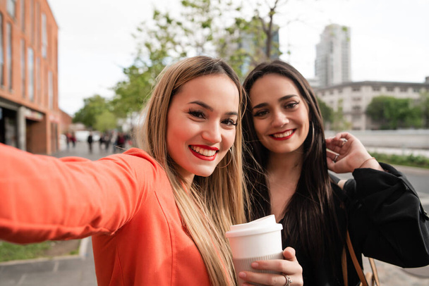 Two young friends taking a selfie outdoors. - Foto, imagen