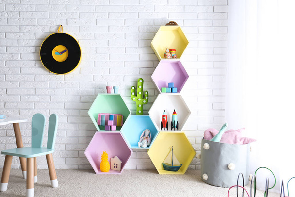 Child room interior with colorful shelves near brick wall - Foto, Imagen
