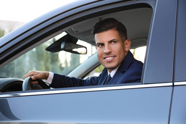 Handsome man in his modern car, view from outside - 写真・画像