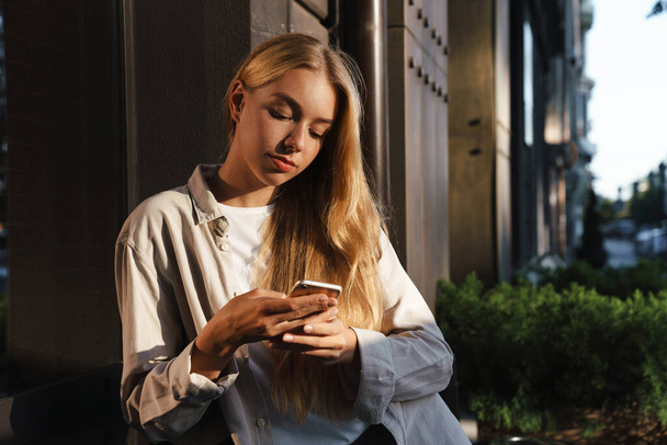 Attractive woman using smartphone on the street - Photo, image