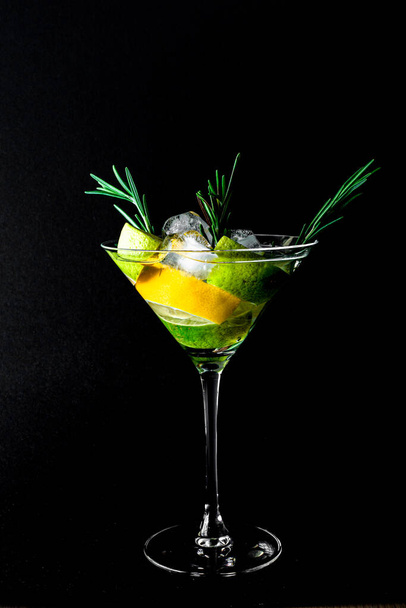 Coctail with orange juce and champagne, lime and lemon on dark background. New Year or Birthday party. Vertical. Copy space. - Fotó, kép