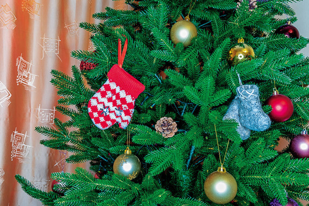 Nahaufnahme eines Weihnachtsbaumzweiges, geschmückt mit Weihnachtsschmuck für das Weihnachtsfest. - Foto, Bild