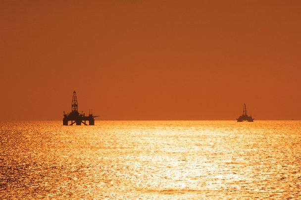 Kaksi öljynporauslauttaa auringonlaskun aikaan Kaspianmerellä
 - Valokuva, kuva