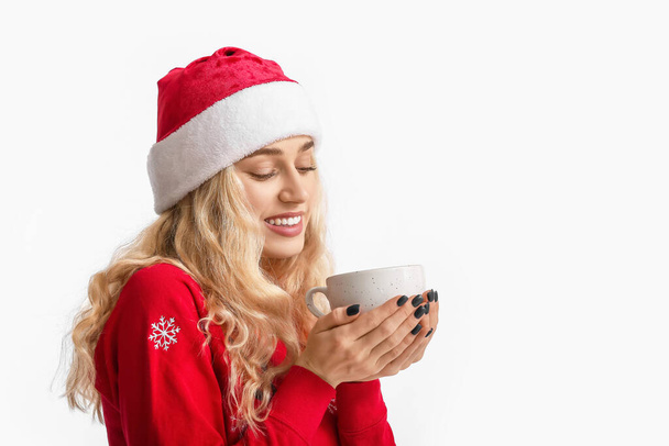 schöne junge Frau mit Weihnachtsmütze auf weißem Hintergrund - Foto, Bild
