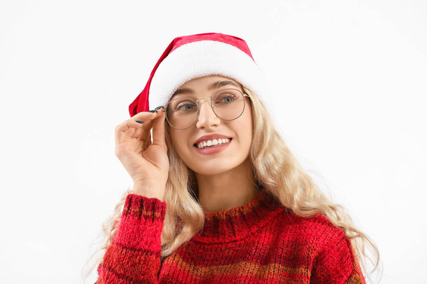 Krásná mladá žena v Santa klobouk a brýle na bílém pozadí - Fotografie, Obrázek