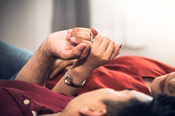Amantes de casal deitado na cama juntos, pinkie contrato é um símbolo mostrando sinceridade uns com os outros, para o conceito dia dos namorados. - Foto, Imagem