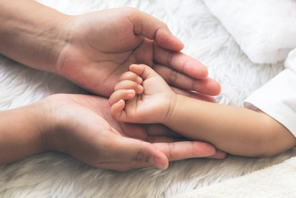 Ręka dziecka umieszczona na ręce matki, koncepcja okazywania miłości i troski o swoje dzieci, i jest relacja rodzinna miłości. - Zdjęcie, obraz