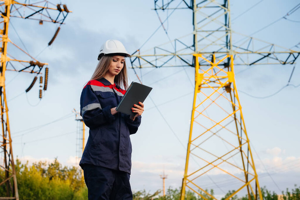 A young engineering worker inspects and controls the equipment of the power line. Energy - Фото, изображение