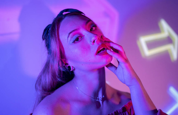 Colorful portrait of a club party woman with multicolored dynamic projector lighting. - Photo, Image