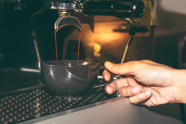 Бариста с использованием Автоматические кофеварки работают путем дистиллирования концентрированной кофе воды, для кофе напиток концепции. - Фото, изображение