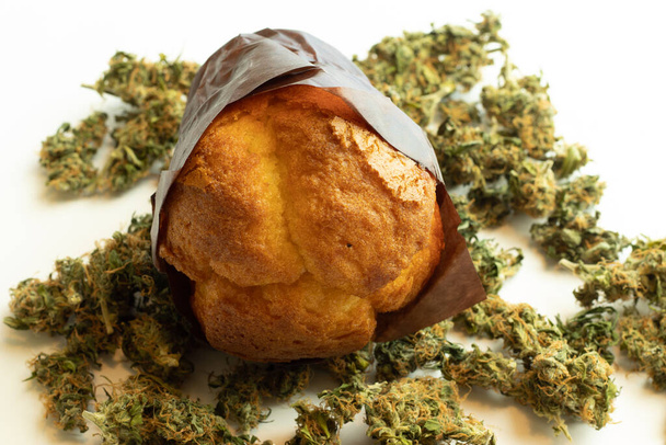 Coffee shop food containing THC. Muffin on cannabis buds. Medical marijuana use for selfcare. - Photo, Image
